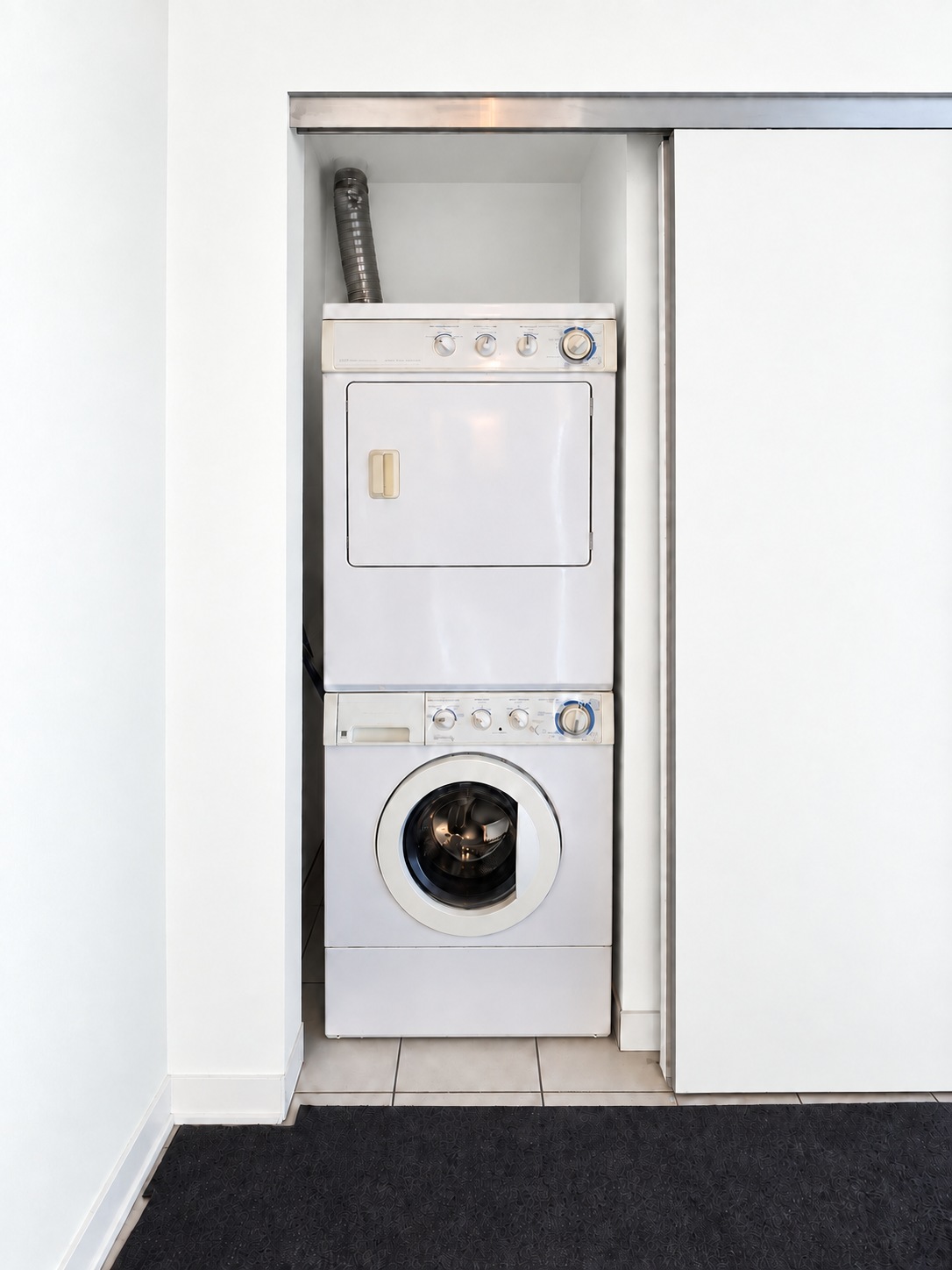 In-suite laundry. Planned paint preview · AI visualization. Your own stacked washer and dryer, neatly tucked into the foyer closet.